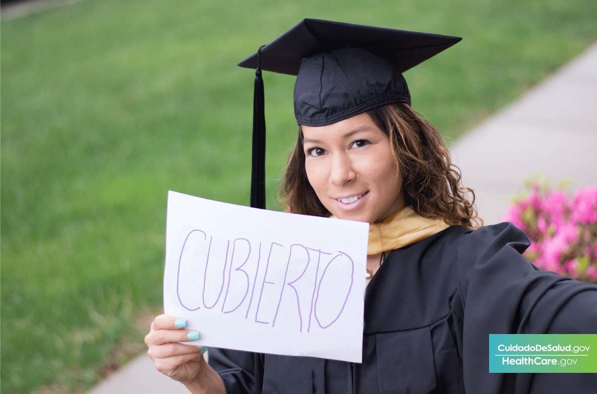 Image: {Graduado sosteniendo un papel diciendo que tiene cobertura médica de recién graduado} 