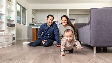 hombre y mujer ven al bebé gatear en el piso