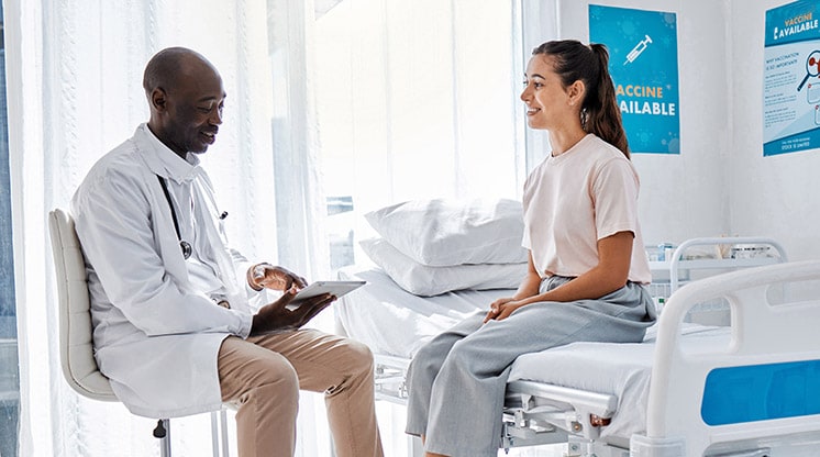 Mujer sentada y hablando con el médico